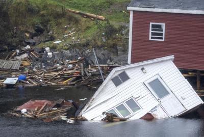 Des bâtiments se tiennent dans l’eau le long de la côte après le passage de l’ouragan Fiona à Rose Blanche-Harbour Le Cou, Terre-Neuve, le 27 septembre 2022. (LA PRESSE CANADIENNE / Frank Gunn) 
