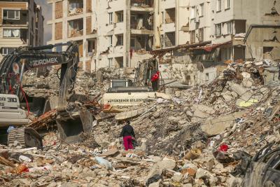 Un homme marche parmi les débris alors que des excavatrices démolissent les restes d’un bâtiment détruit suite au tremblement de terre à Samandag, dans le sud de la Turquie, le 22 février 2023. (Photo AP/Emrah Gurel) Un homme marche parmi les débris alors que des excavatrices démolissent les restes d’un bâtiment détruit suite au tremblement de terre à Samandag, dans le sud de la Turquie, le 22 février 2023. (Photo AP/Emrah Gurel)