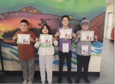 De gauche à droite, Angel MacLeod, Serena Shecapio, Lucas Trapper et Lennox Swallow, élèves de 5e année de l’école primaire Voyageur Memorial de Mistissini, tiennent leur certificat de première place de l’expo-sciences régionale. (École primaire Voyageur Memorial / Facebook)