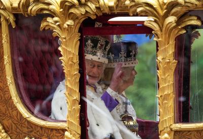 Le roi Charles III salue, aux côtés de la reine Camilla, dans son carrosse lors du cortège royal qui a suivi le couronnement du roi, à Londres, le 6 mai 2023. (LA PRESSE CANADIENNE/Nathan Denette)