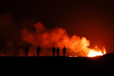 Des gens regardent un volcan en éruption dans le sud-ouest de l’Islande. (Photo via la page Facebook de Getty Images)