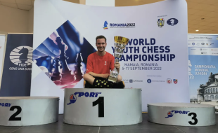 Shawn Rodrigue-Lemieux est photographié avec son trophée après avoir battu des joueurs de 54 pays au championnat du monde d’échecs des moins de 18 ans en Roumanie.
