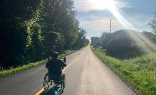 Kevin Mills pédale son vélo avec ses mains.
